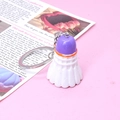 Nahaufnahme eines kreativen Badminton-Schlüsselanhängers in Violett und Orange auf Rosa - Lila