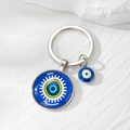 Dettaglio portachiavi Malocchio in argento con pendenti in vetro blu su sfondo di pietra - 21# Base Blu Occhio Sole Bianco