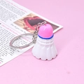 Close-up of a cute mini shuttlecock keychain with pink cap and blue ring detail - Pink