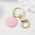 Detailed close-up of pink enamel Girls charm with gold lobster clasp and round key ring - Pink Round Style (Girls)