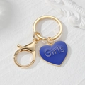 Détail d'un porte-clés cœur bleu avec texte Girls et fermoir doré sur marbre blanc - Style Cœur Bleu Roi (Girls)