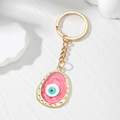 Pink marble evil eye keychain with gold chain on a minimalist white background - Red Oval Eye