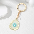Detail van gouden onregelmatige ovale sleutelhanger met blauw-wit boze oog motief - Wit Ovaal Oog