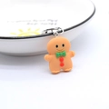 Detail of gingerbread man resin keychain with silver clasp on white porcelain tray - Gingerbread Man