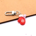 Detailed view of a red festive resin glove keychain with a cute pink bunny and snowflake - Snowflake Glove