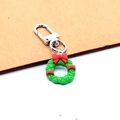 Close-up of a green Christmas wreath keychain with red bows and silver metal clasp - Bow Wreath