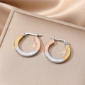 Detail of twisted hoop earrings with three-tone gold and silver radial texture - Striped Textured Style