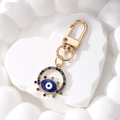 Detailansicht des Evil Eye Schlüsselanhängers mit bunten Strasssteinen und Gold-Emaille - Dunkelblaues Auge