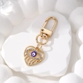 Portachiavi a cuore dorato con malocchio viola e strass scintillanti su sfondo bianco - Cuore Occhio Viola / Viola
