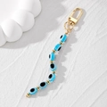 Dettaglio portachiavi malocchio con perle in resina blu e chiusura a moschettone dorata - Perline Ovali Celeste