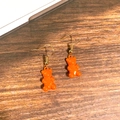 Detailansicht der leuchtend orangefarbenen Gummibärchen-Ohrhänger mit Goldhaken - Orangener Bär