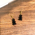 Close-up of cute black bear drop earrings with golden hooks on a wooden background - Black Bear