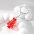 Makroaufnahme von rotem Weihnachtshaenger mit Laserbeschichtung auf weißem Requisit - Aurora Stil / Roter Weihnachtsbaum