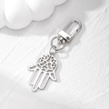 Detailed silver Hamsa hand keychain with intricate hollow carvings on stone texture - Silver Hollow Hamsa