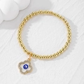Handmade gold beaded bracelet with a four-leaf clover evil eye pendant and rhinestones - Four-leaf Clover / Royal Blue Eye Flower