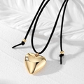 Collier minimaliste avec pendentif cœur doré et cordon ajustable en daim noir sur fond blanc - Doré