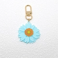 Detailopname van blauwe madeliefje sleutelhanger met glitters en gouden sluiting - Sleutelhanger Hanger (C172K) / Hemelsblauw