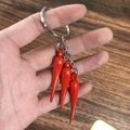 Dettaglio di ciondoli a peperoncino rosso in resina su portachiavi argento - Peperoncino