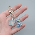 Macro view of colorful translucent rabbit charm and glitter star on a metal keychain - Transparent Blue