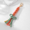 Detailansicht handgefertigter Schlüsselanhänger mit rosa Gänseblümchen und Schleife - Orangerot