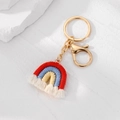 Dettaglio portachiavi arcobaleno in cotone intrecciato con nappe bianche e chiusura oro - Arcobaleno rosso