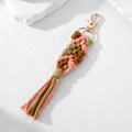 Close-up of bohemian handmade woven keychain with pink, olive, and brown cotton tassels - Brown Pink