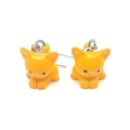 Primer plano de lindos pendientes de gatito naranja de resina con ganchos de metal fino - Gato