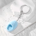 Close-up of light blue flocked mini slipper keychain on a white stone pedestal - Sky Blue