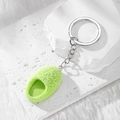 Detail view of a green fuzzy mini slipper keychain with silver metal ring and soft texture - Green