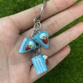 Detailopname van de blauwe aardbeientaart hangers aan een metalen sleutelhanger - Blauwe Aardbeientaart