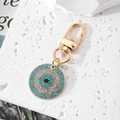 Detail of evil eye keychain with blue and white rhinestones on golden swivel lobster clasp - Gold Sky Blue
