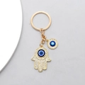 Goldener Hamsa-Hand-Schlüsselanhänger mit blauem Evil Eye und Glitzersteinen - Goldene Hand der Fatima und Böser Blick Stil / Gold