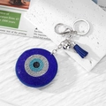 Llavero de ojo turco azul con pedrería brillante y borlas en un fondo decorativo - Plata Azul Oscuro