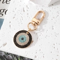Dettaglio del portachiavi occhio di Allah placcato oro con strass blu scintillanti - Oro Zirconia Nera