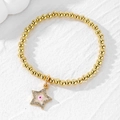 Golden beaded stretch bracelet with star charm and pink evil eye crystal inlay - Pink Eye Star