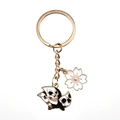 Detail of gold metal keychain with stacked skull charms and white enamel cherry blossom - Taking Off Butterfly And White Sakura