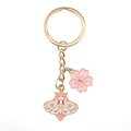 Macro shot of cherry blossom and moth pendant keychain with pink enamel details - Pink Butterfly And Pink Sakura
