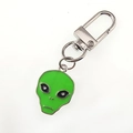 Detailed macro view of a fluorescent green UFO alien keychain with silver enamel finish - Green Alien