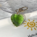 Exquisiter grüner Kristallherz Schlüsselanhänger mit goldenem Verschluss auf Keramiktablett - Grünes Großes Herz
