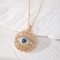 Vue détaillée du pendentif œil maléfique doré avec filigrane et strass brillants - Mauvais Oeil Or