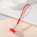 Detailed view of Maneki Neko lucky cat charm with red woven cord and gold lettering - Red