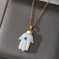 Ethnic Hamsa Hand necklace with blue Evil Eye pendant on gold chain and jewelry box - White
