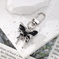 Detail of silver crystal butterfly keychain with black faceted gemstones on stone background - Black Butterfly