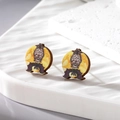 Macro detail of wooden Halloween earrings with owl and moon print on ceramic base - Bat and Owl