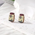Detail of potion bottle wooden earrings with moth and spider specimen prints on stone base - Bottle