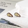Détail de boucles d'oreilles en bois en forme de goutte aux motifs géométriques colorés - Ruban correcteur