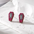 Macro shot of coffin-shaped wooden earrings with purple glitter and owl print detail - Owl Magenta Coffin