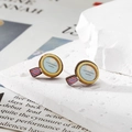 Vue détaillée de boucles d'oreilles créatives en forme de miroir sur socle en pierre - Loupe