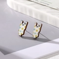 Detail of wooden ghost earrings with colorful dot print on a stylish white ceramic tray - Smiling Ghost
