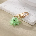Detailed macro view of a green and white glass octopus keychain with a golden metal clasp - Green